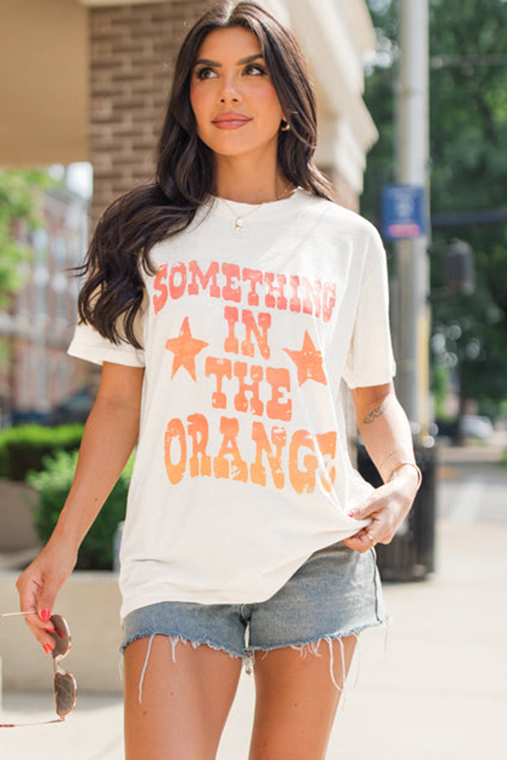 Camiseta branca com estampa SOMETHING IN THE ORANGE e gola redonda